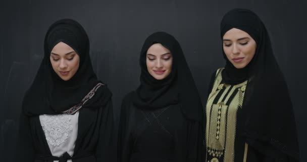 Групповой портрет красивых мусульманских женщин в модном платье с хиджабом на фоне черной доски — стоковое видео