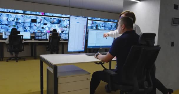 Dva strážci monitorující moderní kamery CCTV ve sledovací místnosti — Stock video