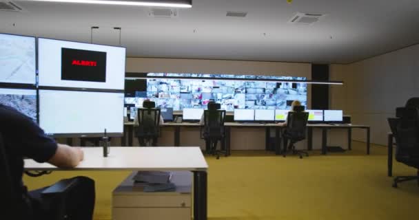 Охранники следят за современными камерами наблюдения в комнате наблюдения — стоковое видео
