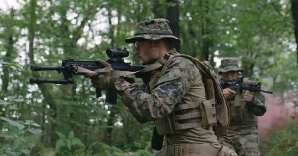 Grupa żołnierzy poruszających się przez las smokey z karabinem gotowym do strzału, biegnących przez las podczas akcji wojskowej — Wideo stockowe