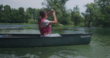 Nehirde kayak yapan ve doğada macera yaşayan bir çift.