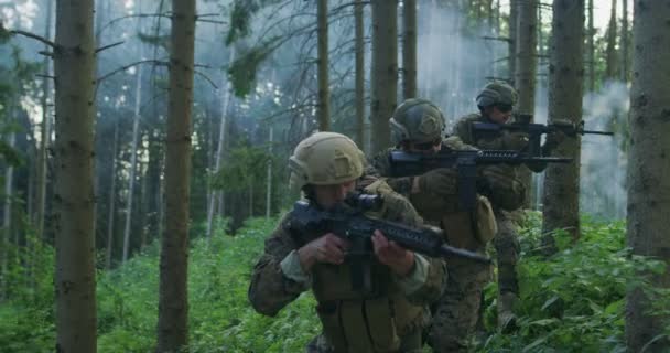 Millitary művelet gorup katonák támadó ellenséges vonal sűrű erdőben napközben — Stock videók