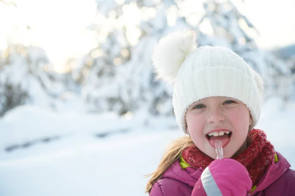 Bonito menina enquanto comer o gelo no belo dia de inverno — Fotografia de Stock