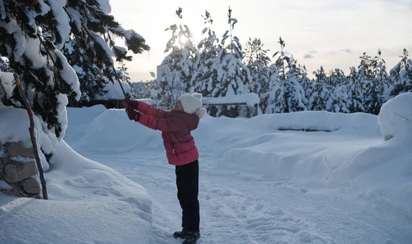 Дівчина кидає свіжий сніг в красивий сонячний зимовий день — стокове фото