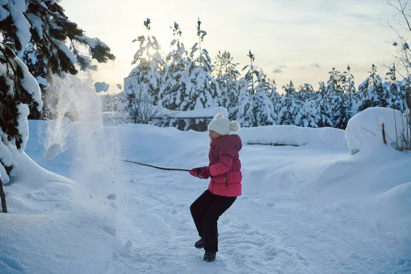 女孩在美丽阳光明媚的冬日里扔新雪 — 图库照片