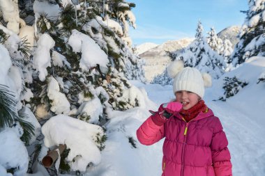 Güzel bir kış günü buz saçağı yerken tatlı küçük kız