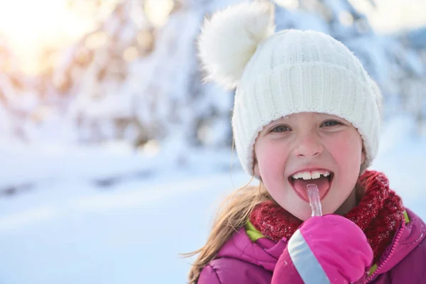 Bonito menina enquanto comer o gelo no belo dia de inverno — Fotografia de Stock