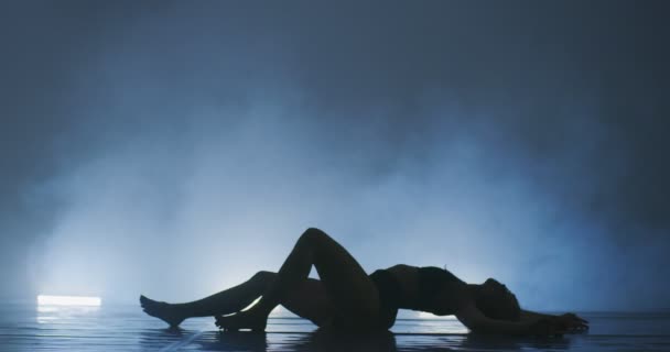 Танцовщица современного балета, практикующая в дымчатой атмосфере, стройная гибкая танцовщица во время танцевальной практики — стоковое видео