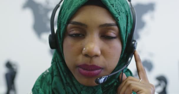 Närbild av glad islamisk affärskvinna med hijab bär ett headset när du står i det moderna kontoret — Stockvideo