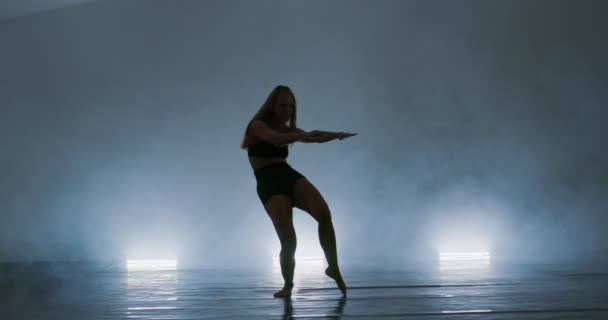 Bailarina de ballet contemporáneo practicando en ambiente ahumado, esbelta intérprete de danza flexible durante una práctica de danza — Vídeos de Stock