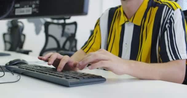 Masaüstü bilgisayarında çalışan yakışıklı genç işadamı başlangıç ofisinde masasında oturuyor. — Stok video