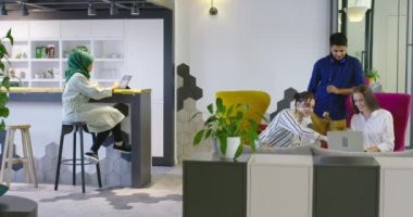 Çok ırklı bir girişim ekibi, modern parlak ofis içi beyin fırtınası, başlangıç ofisinde dizüstü bilgisayar ve tablet bilgisayar üzerine çalışıyor