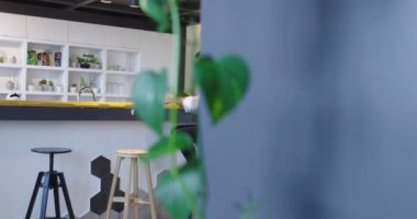 Profesyonel bir iş kadınının portresi sandalyede günlük oturuyor ve başlangıç ofisinde tabletle çalışıyor.