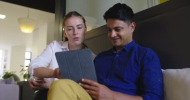Başlangıçta dijital tablet kullanarak fikirleri tartışan, etnik kökenli iki çekici insan, bir sonraki iş için toplantı ve planlama yapıyor. 