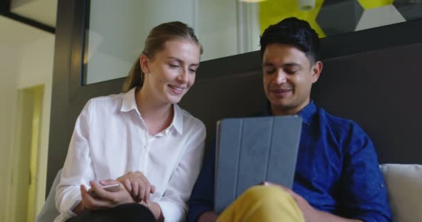 Two attractive people mixed ethnicity discussing ideas using digital tablet at startup office, meeting and planing next business — Stock Video