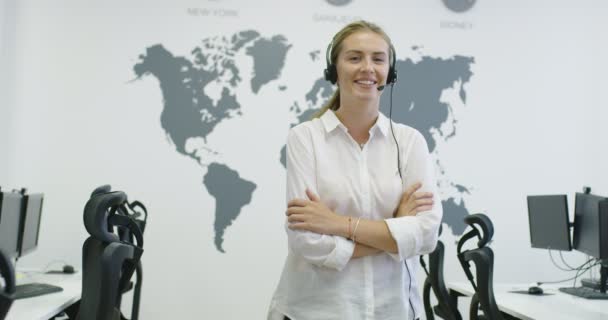 Bella giovane donna operatore in piedi e indossando auricolare allo spazio ufficio luminoso — Video Stock