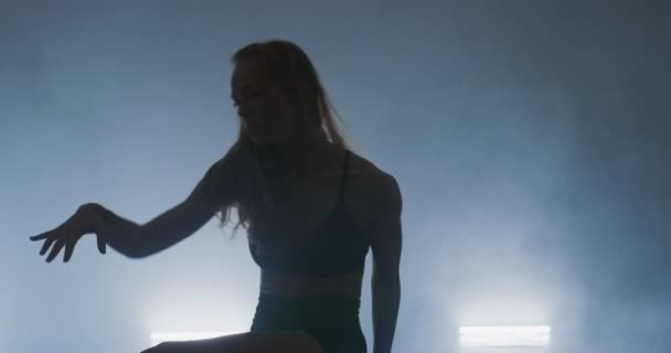 Bailarina de ballet contemporáneo practicando en ambiente ahumado, esbelta intérprete de danza flexible durante una práctica de danza — Vídeos de Stock
