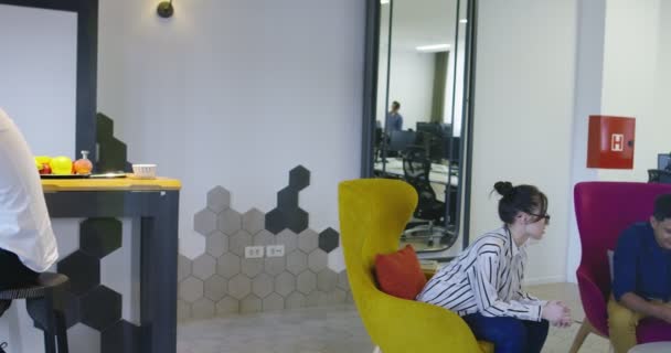 Багатоетнічна стартап бізнес команда на зустрічі в сучасному яскравому офісному інтер'єрі мозкового штурму, що працює на ноутбуці і планшетному комп'ютері в стартовому офісі — стокове відео