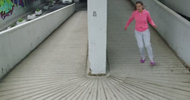 Şehir merkezinde şehir sokağında koşan genç bir bayan sporcu.. 