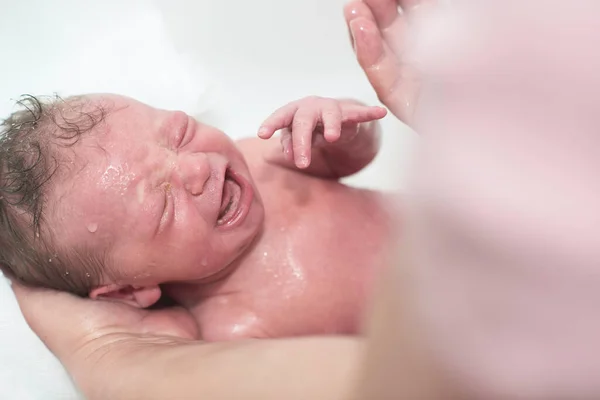 Новорожденная малышка принимает первую ванну — стоковое фото
