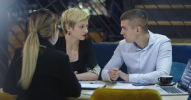 İş arkadaşları kafede birlikte çalışıyor, toplantılar yapıyor ve kahve içiyorlar.