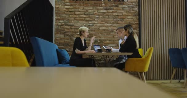 Група молодих бізнесменів зібралася разом для обговорення творчої ідеї в кафе — стокове відео