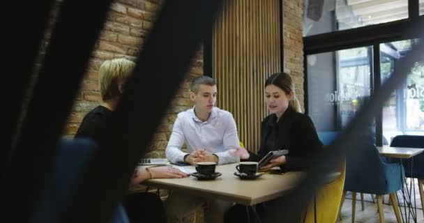 Groupe de jeunes gens d'affaires se sont réunis pour discuter d'idées créatives dans un café — Video