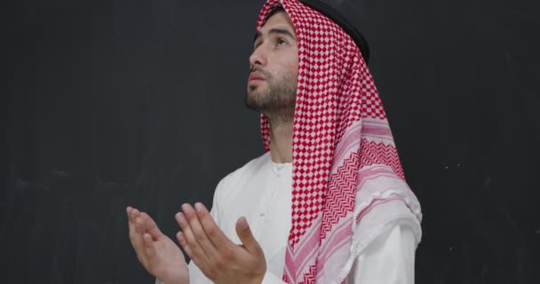 身穿传统服装的阿拉伯年轻人向上帝祈祷，在黑色黑板前保持双手祈祷的姿势 — 图库视频影像
