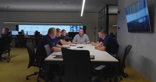 Grupo de guardas de segurança sentados e tendo reunião no centro de segurança moder — Vídeo de Stock