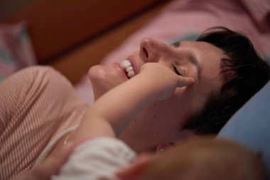 Anne evde bebekle oynuyor.