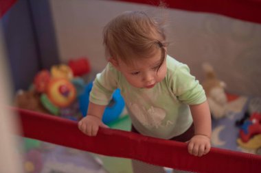 Gezici yatakta oynayan sevimli küçük bebek.