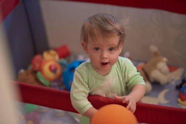 Gezici yatakta oynayan sevimli küçük bebek.