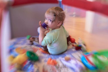 Gezici yatakta oynayan sevimli küçük bebek.