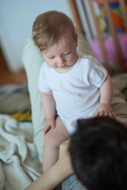 Anne evde bebekle oynuyor.