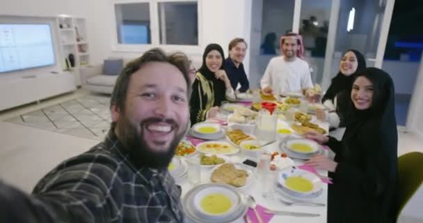 Familia musulmana de Eid Mubarak cenando con Iftar tomando fotos con teléfono móvil mientras come comida tradicional durante el mes de fiesta del Ramadán en casa — Vídeos de Stock