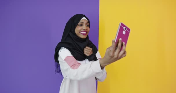 幸せなarab女性でhijabで携帯電話作る自己愛の色の背景 — ストック動画