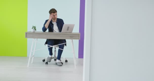 Joven guapo usando un portátil en una oficina moderna, freelancer trabajando en casa nuevo proyecto — Vídeos de Stock