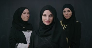 Siyah karatahta izole edilmiş tesettüre sahip şık giyinmiş güzel Müslüman kadınların toplu portresi 