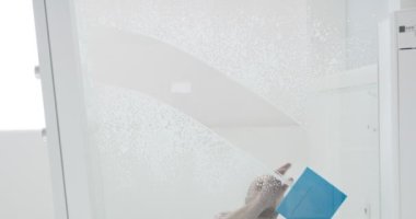 Modern dairede camları sıkan bir adam, hizmetkar cam yüzeyi.