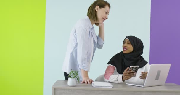 Diversidade Reunião de mulheres étnicas no escritório. Menina sorridente no Hijab trabalhando no laptop, loira olhando para a tela. — Vídeo de Stock