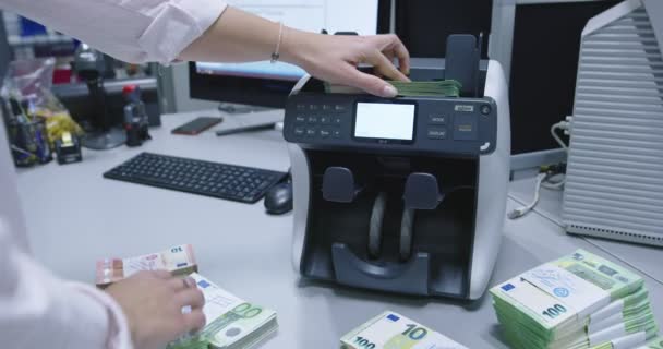 Boekhouder die verschillende soorten contante bankbiljetten opneemt nadat deze door de telmachine zijn geteld — Stockvideo