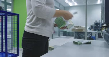 Muhasebeci, hesap makinesi tarafından sayıldıktan sonra çeşitli nakit banknotlarını geri çeker