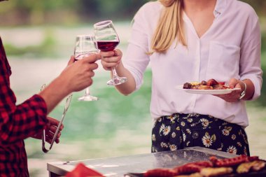 Piknik yaparken arkadaşlarımız kırmızı şarap kadehlerini kızartıyorlar.