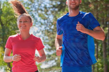 Çiftler, köy yolunda koşarken sağlıklı bir yaşam tarzının keyfini çıkarıyorlar.