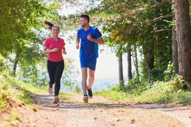 Çiftler, köy yolunda koşarken sağlıklı bir yaşam tarzının keyfini çıkarıyorlar.