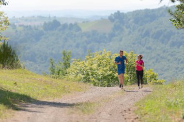 Çiftler, köy yolunda koşarken sağlıklı bir yaşam tarzının keyfini çıkarıyorlar.