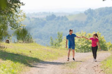 Çiftler, köy yolunda koşarken sağlıklı bir yaşam tarzının keyfini çıkarıyorlar.