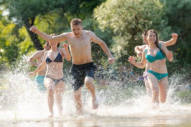 Bir grup mutlu arkadaş nehirde eğleniyor.