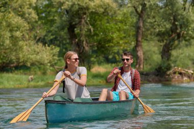 Arkadaşlar vahşi bir nehirde kano yapıyorlar.