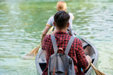 Arkadaşlar vahşi bir nehirde kano yapıyorlar.